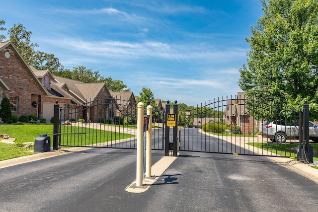 view of gate featuring a yard and a residential view