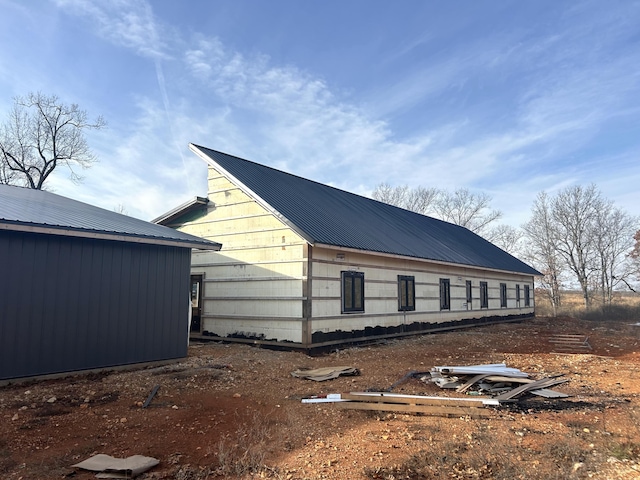 view of home's exterior featuring metal roof and an outbuilding