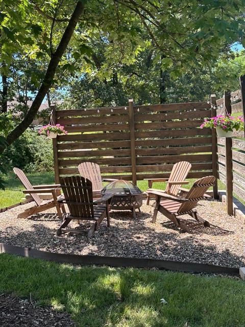 exterior space featuring an outdoor fire pit and fence