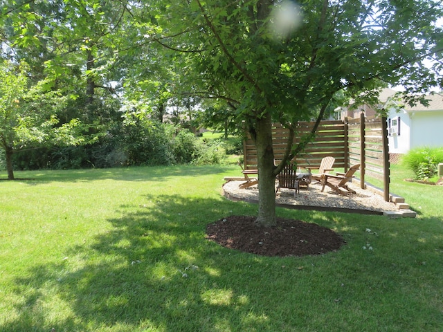 view of yard with an outdoor fire pit and fence