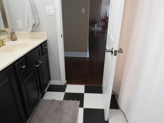 bathroom with vanity, baseboards, and tile patterned floors