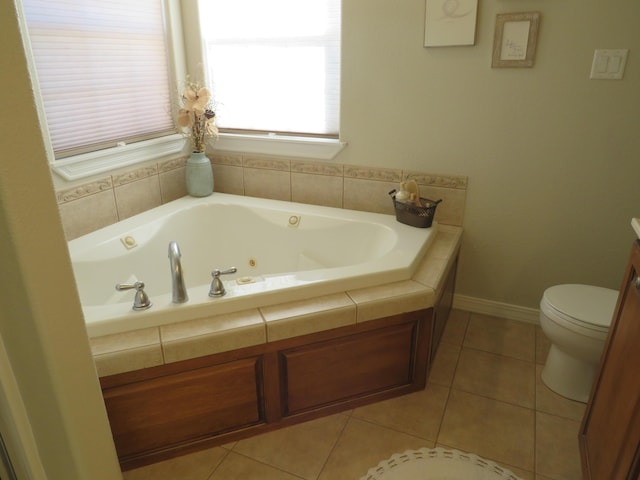 full bath with a jetted tub, tile patterned flooring, toilet, and baseboards