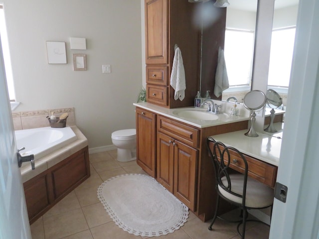 bathroom featuring baseboards, toilet, tile patterned floors, a garden tub, and vanity