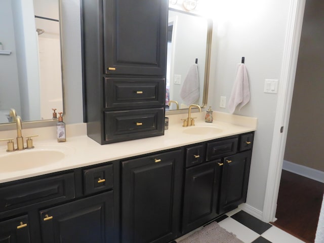 full bathroom with tile patterned floors, a sink, baseboards, and double vanity