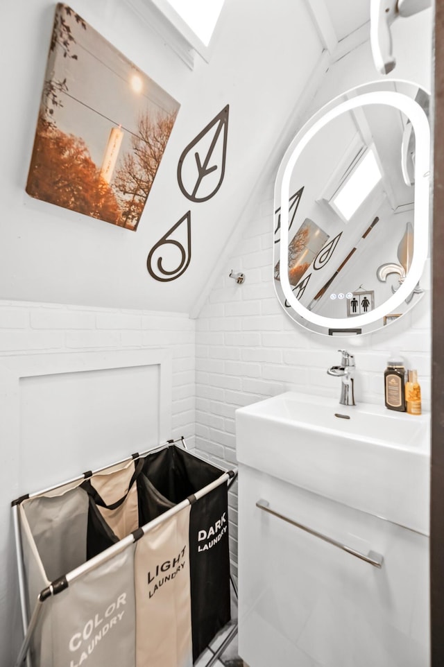 bathroom featuring lofted ceiling and a sink