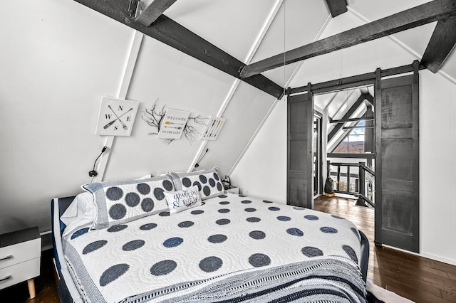 bedroom with lofted ceiling with beams, a barn door, and dark wood finished floors