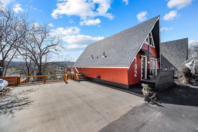 view of side of home with a shingled roof