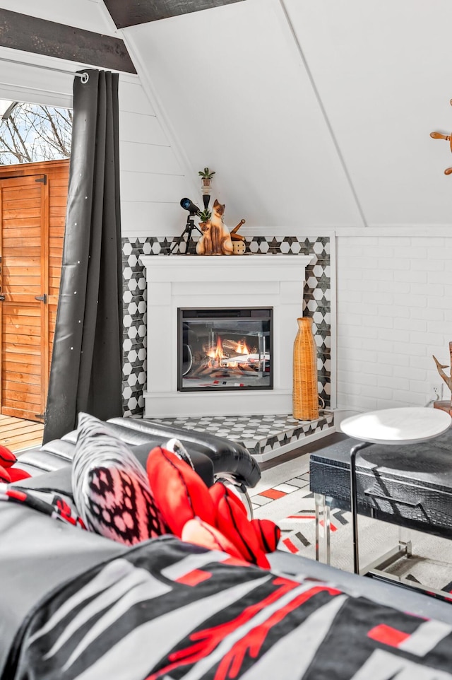 interior space featuring brick wall and a glass covered fireplace