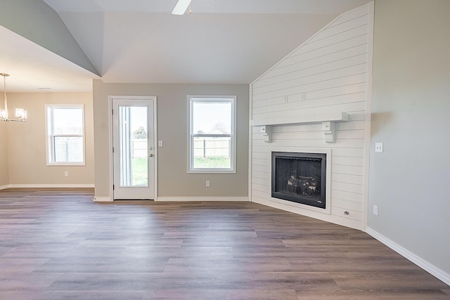 unfurnished living room featuring lofted ceiling, a large fireplace, baseboards, and dark wood-style flooring