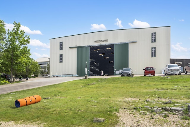 view of building exterior with a detached garage and a pole building