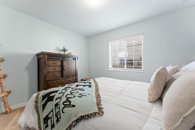 bedroom with light carpet and baseboards