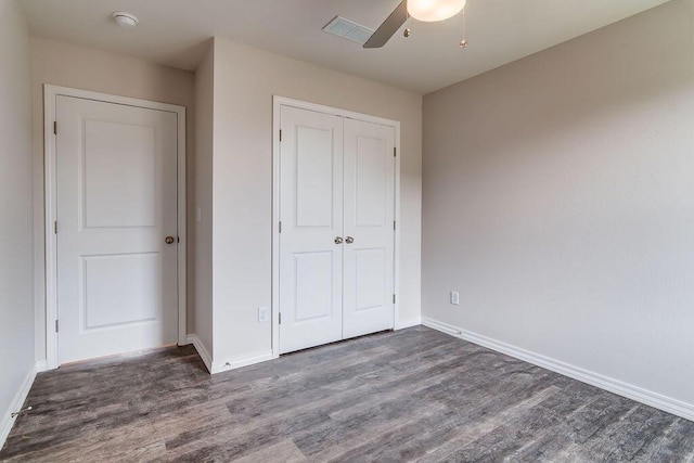 unfurnished bedroom featuring ceiling fan, wood finished floors, visible vents, baseboards, and a closet