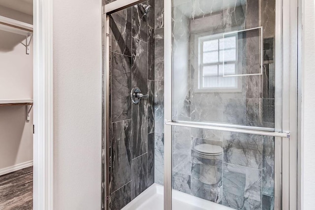 bathroom featuring a stall shower and a walk in closet