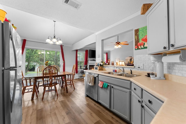 kitchen with gray cabinets, visible vents, appliances with stainless steel finishes, a sink, and wood finished floors