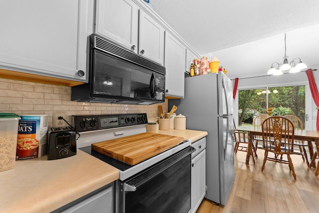 kitchen with light wood-style flooring, black microwave, light countertops, and electric stove