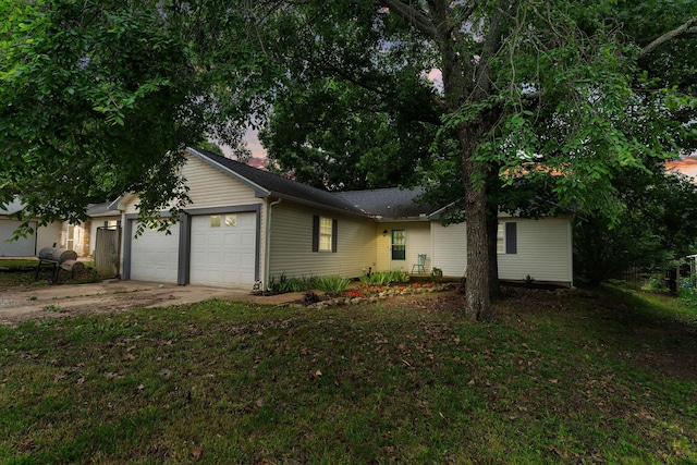 ranch-style home with driveway, a front lawn, and an attached garage