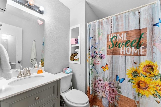 full bath featuring a shower with curtain, a textured wall, vanity, and toilet