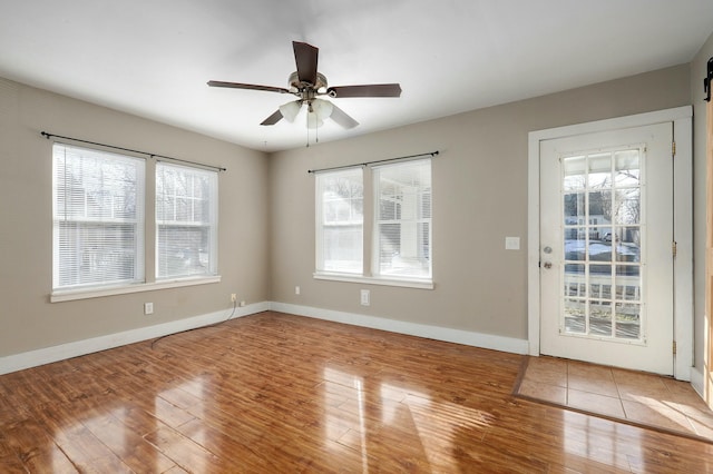 interior space featuring a ceiling fan, baseboards, and wood finished floors