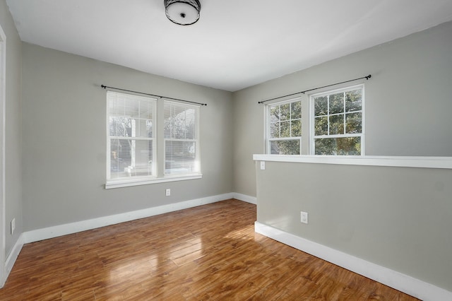 empty room with baseboards and wood finished floors