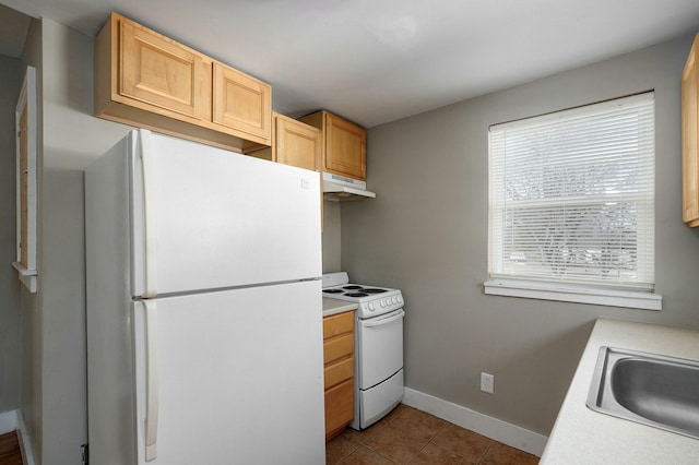 kitchen featuring white appliances, light countertops, a sink, and tile patterned floors