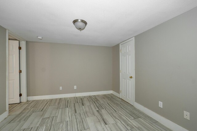 unfurnished room featuring light wood-type flooring and baseboards