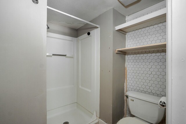 full bathroom featuring toilet and a stall shower