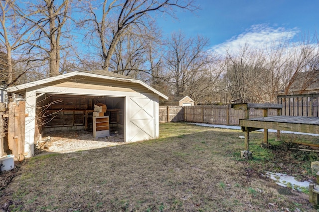 view of yard featuring an outbuilding, a shed, a fenced backyard, and a garage