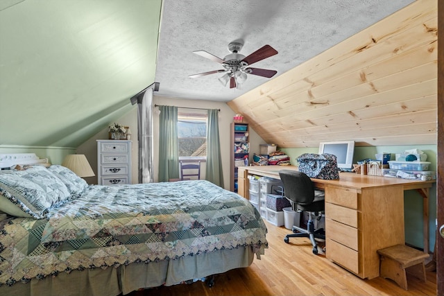 bedroom featuring a textured ceiling, wood finished floors, and lofted ceiling