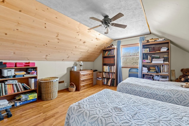 bedroom featuring a textured ceiling, vaulted ceiling, and wood finished floors