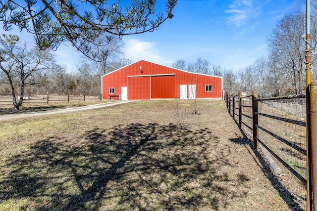 view of pole building with a lawn and fence