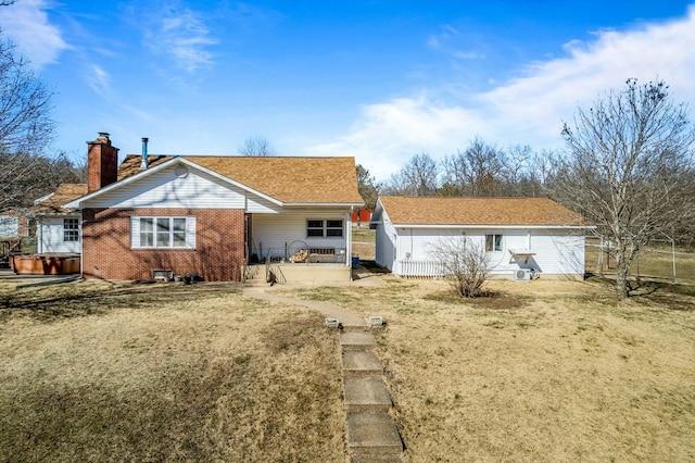 rear view of house featuring brick siding and a chimney