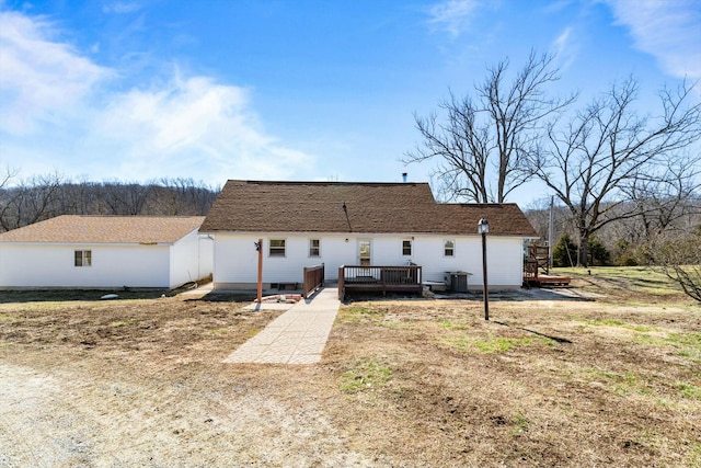 rear view of property featuring a wooden deck and central AC unit