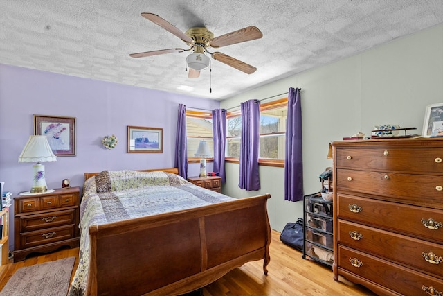 bedroom with a ceiling fan, light wood-style flooring, and a textured ceiling