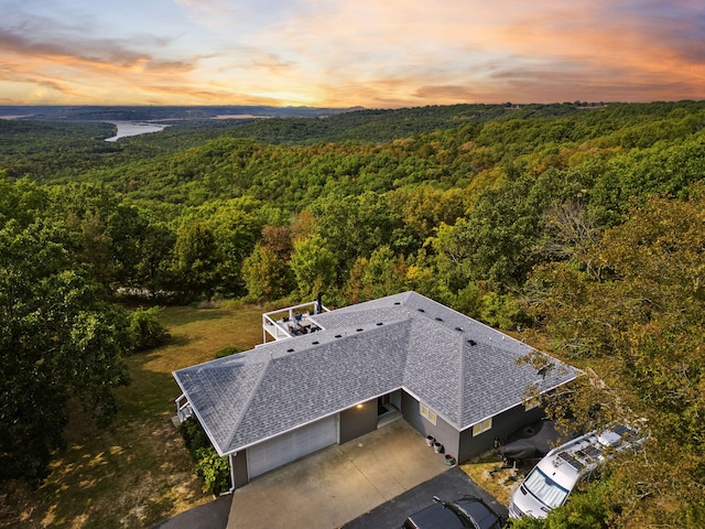 drone / aerial view featuring a wooded view