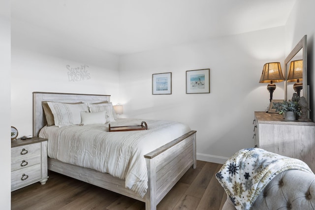 bedroom with baseboards and dark wood-type flooring