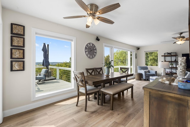 dining space with light wood-type flooring, a ceiling fan, and baseboards