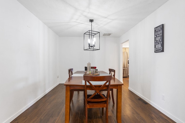 dining space featuring an inviting chandelier, baseboards, visible vents, and dark wood-style flooring