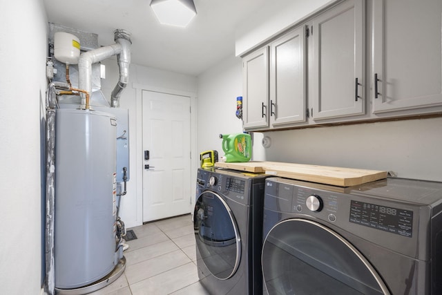 laundry room with washer and dryer, water heater, cabinet space, and light tile patterned floors