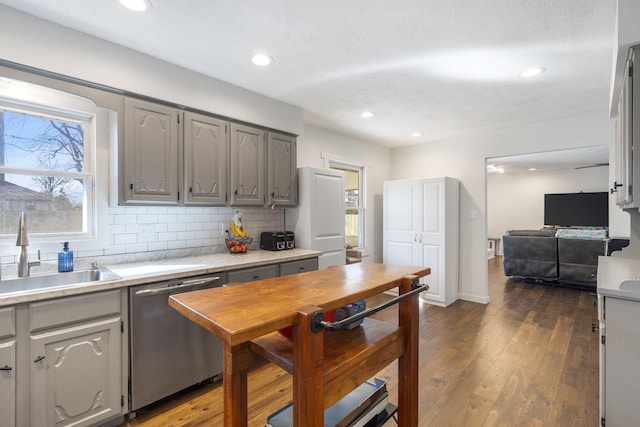 kitchen with gray cabinets, a healthy amount of sunlight, dishwasher, and a sink