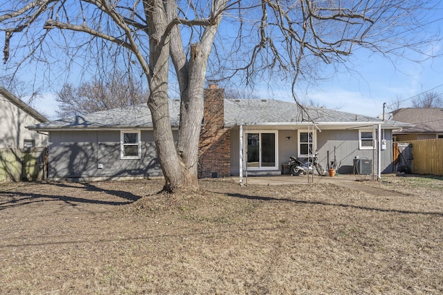 back of property with entry steps, a chimney, fence, and central air condition unit