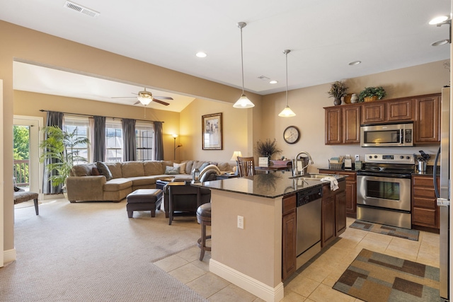 kitchen with visible vents, stainless steel appliances, a sink, and open floor plan