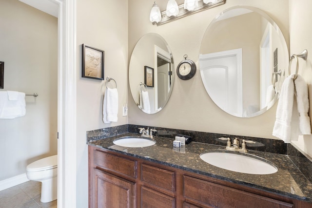 bathroom featuring tile patterned flooring, a sink, toilet, and double vanity