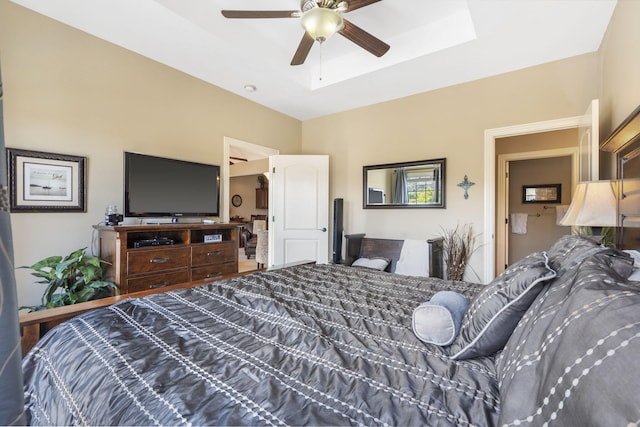 bedroom with ceiling fan and a raised ceiling