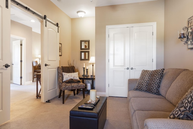 living room featuring light carpet, baseboards, and a barn door