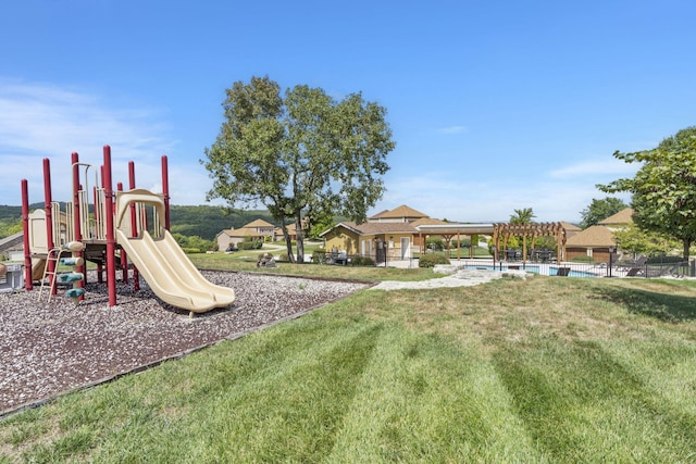 community playground with a lawn, an outdoor pool, and a pergola