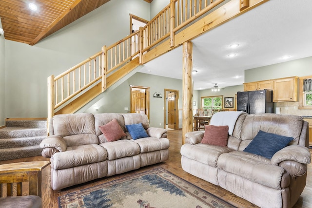 living room featuring recessed lighting, wood finished floors, a towering ceiling, baseboards, and stairway