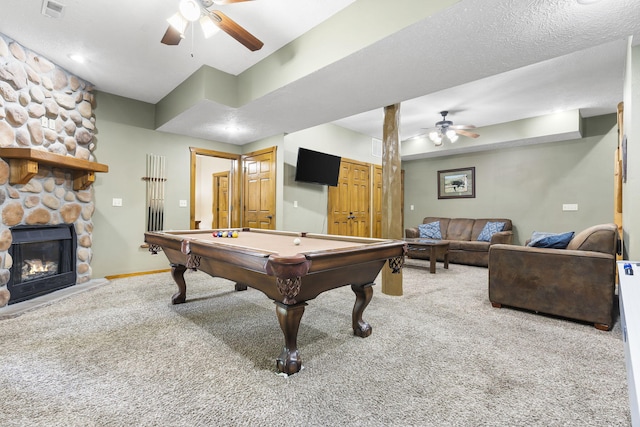 game room featuring ceiling fan, a stone fireplace, visible vents, and light colored carpet