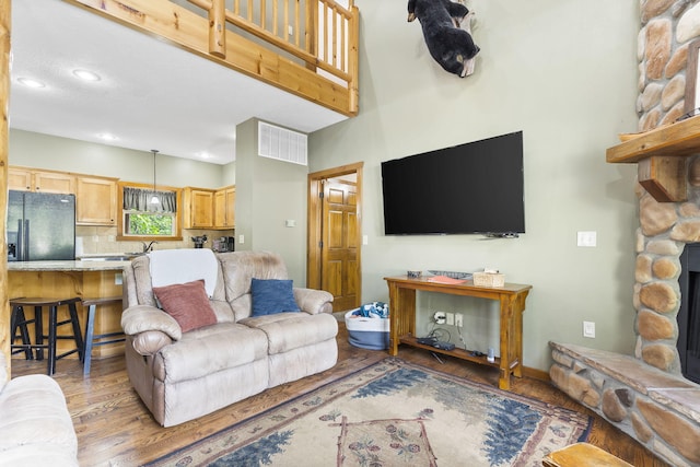 living area featuring light wood-type flooring, a fireplace, and recessed lighting