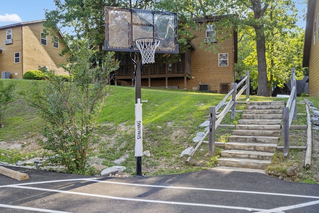 view of sport court featuring a lawn and stairway