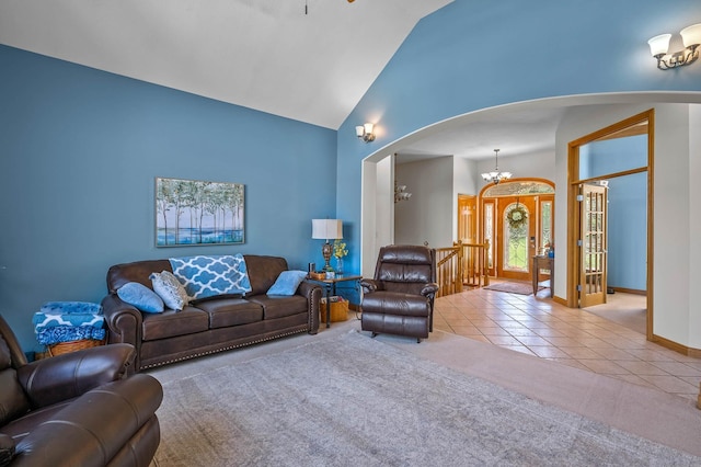 living room featuring a chandelier, high vaulted ceiling, arched walkways, tile patterned flooring, and carpet floors